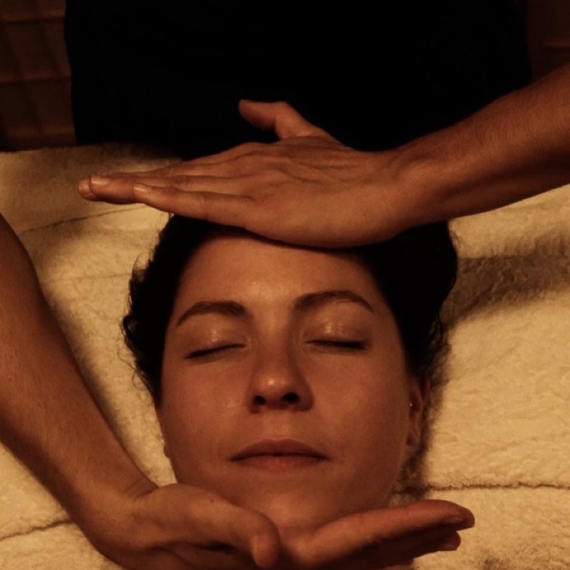 Hands performing energy healing and magnetism over the face
